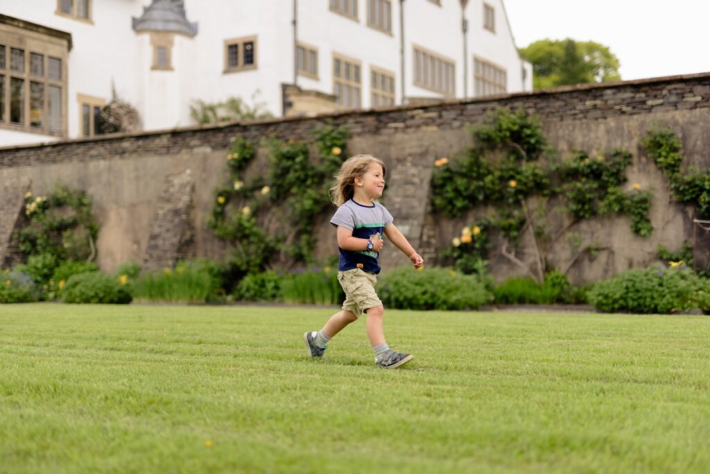 child running happily across the lawn at Blackwell – the Arts & Crafts house.