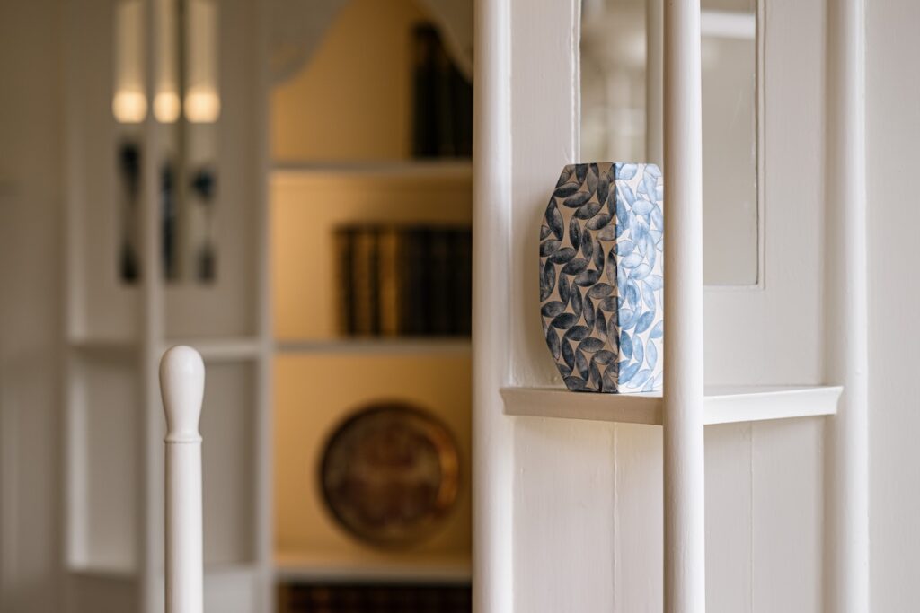 Close up of checkered blue and white ceramic sculpture by Frances Priest on the shelves near the windows in the White Drawing Room.