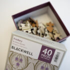 Annie Garnett Fritilliary-inspired jigsaw pieces on show in an open box placed on a white table.
