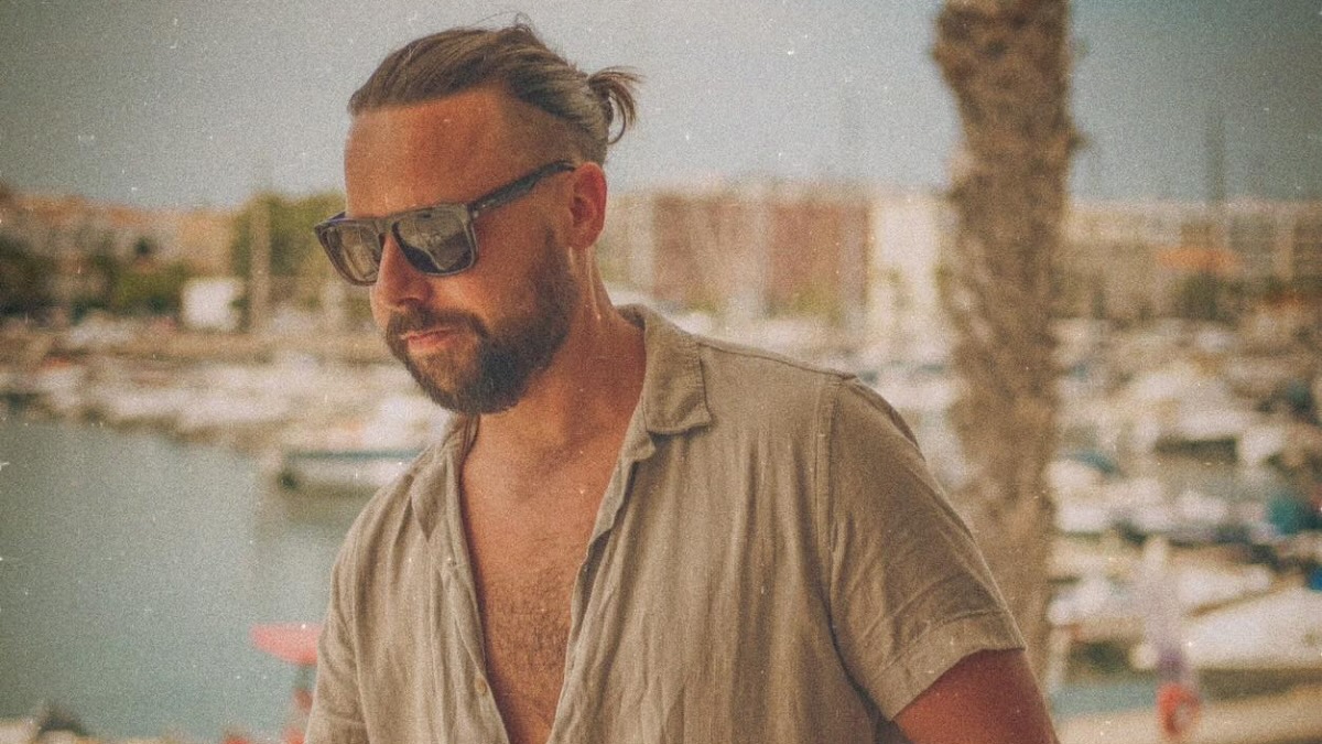 Musician Jon Dawes posing near a lakeside setting.