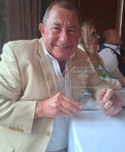 A man holding a glass trophy at the Pride of Cumbria Awards