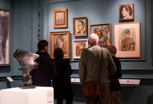 A group of people looking at the Portrait Gallery in Abbot Hall.