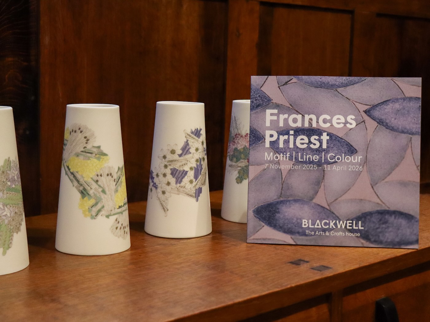 Frances Priest catalogue on display against Frances Priest's artworks on display,