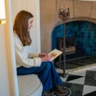 Artist Tiana McInerney painting her fire dog illustration near the inglenook fireplace in the White Drawing Room at Blackwell house.