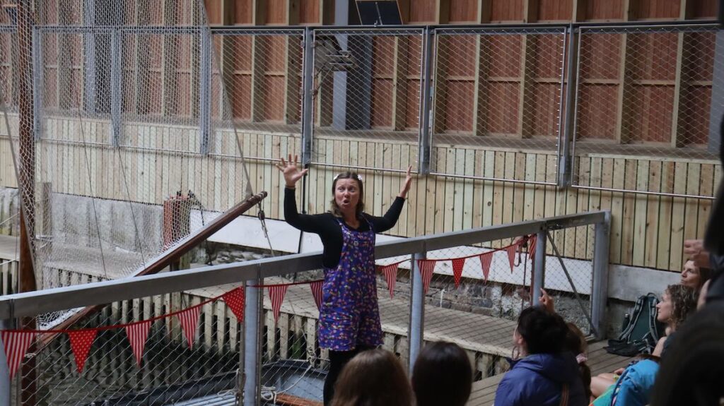 Person storytelling to families in Boathouse at Windermere Jetty Museum.